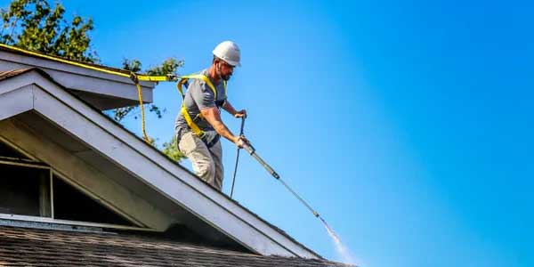 Man spraying roof treatment on roof
